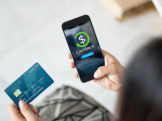 Image of a man holding a credit card and cell phone